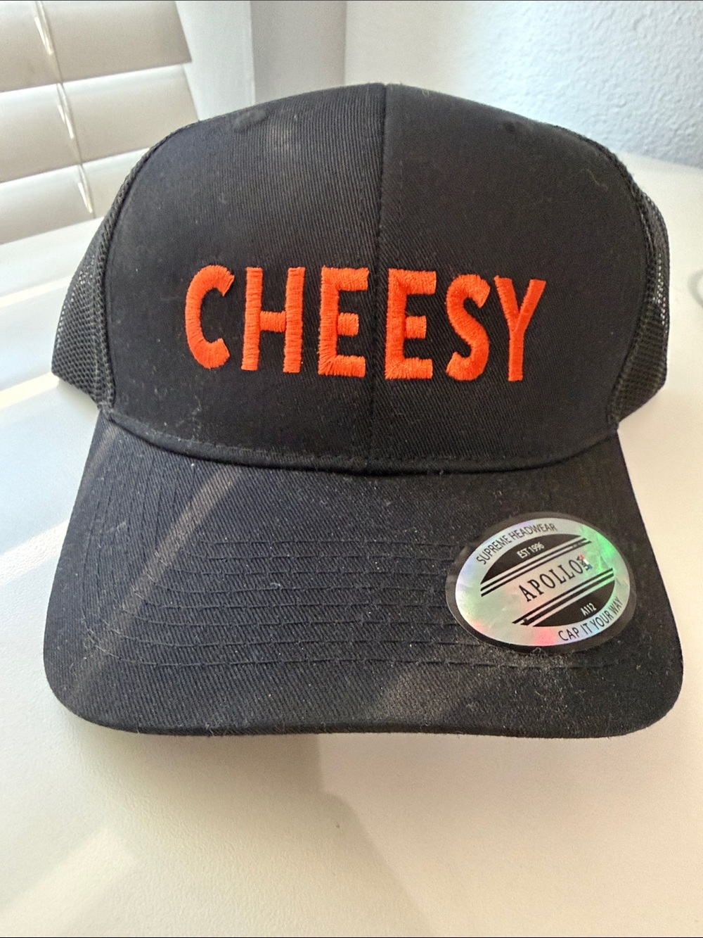 CHEESY Embroidered Black Trucker Cap with Orange Lettering